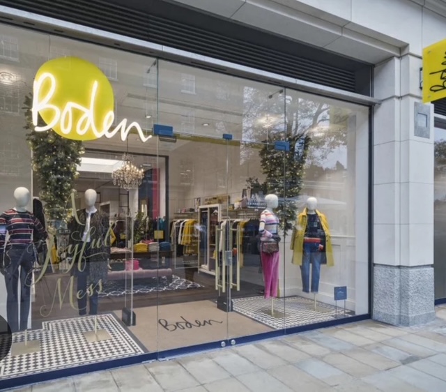 Vetrina del negozio Boden a Londra, con mannequin che indossano abbigliamento colorato e moderno.