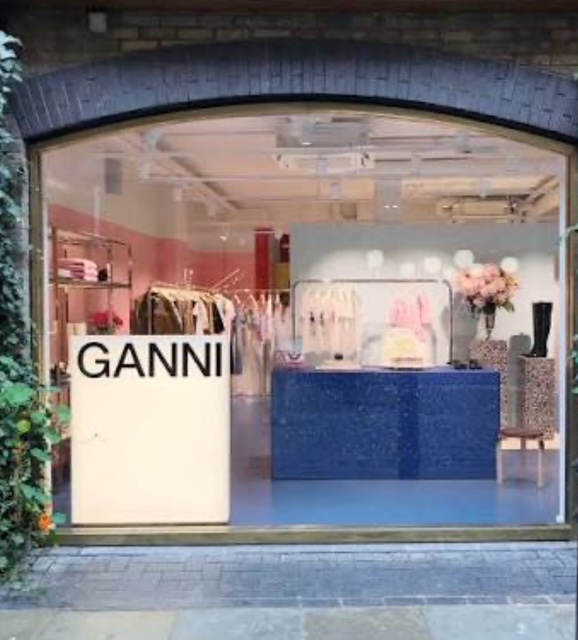 Vetrina del negozio Ganni a Londra, con decorazioni colorate e un design moderno.