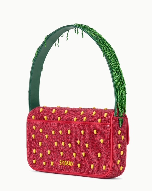 Borsa a tracolla rossa di Staud, decorata con perline gialle a forma di fragole e manico verde.
