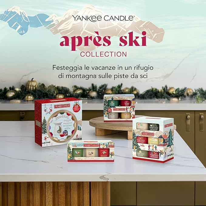 Collezione di candele profumate "Après Ski" di Yankee Candle, presentata su un tavolo con decorazioni natalizie sullo sfondo.