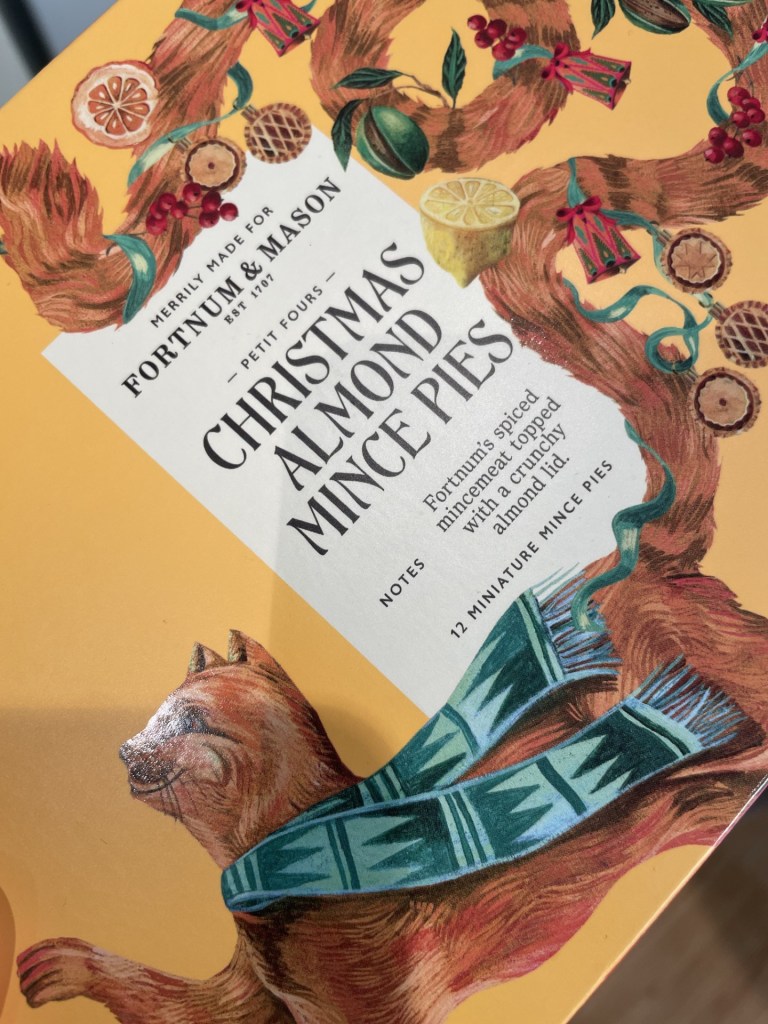 Packaging of Christmas Almond Mince Pies from Fortnum & Mason featuring decorative illustrations of a cat and festive elements.