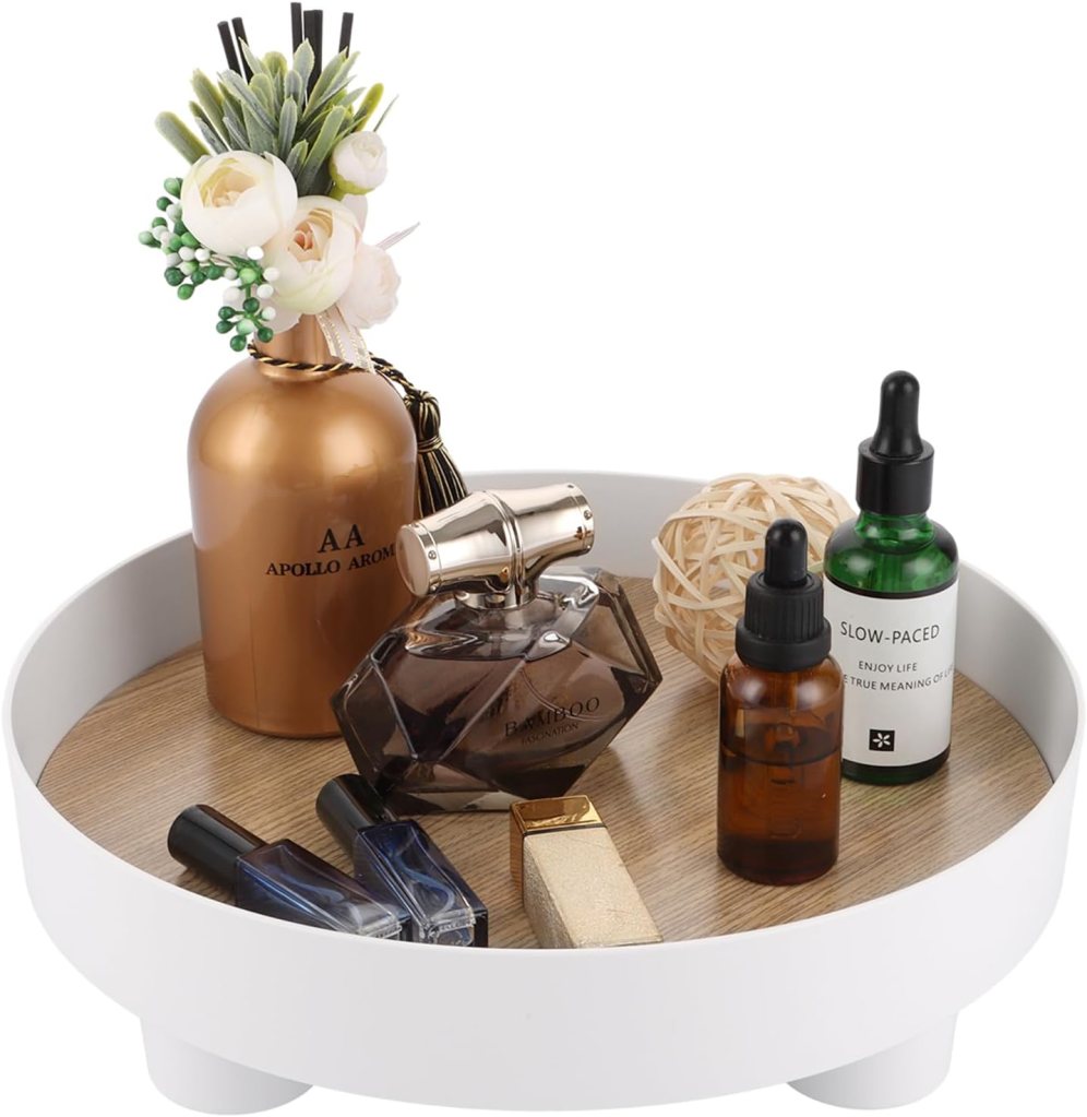 Un vassoio bianco con una selezione di cosmetici, tra cui profumi, oli e smalti, decorato con fiori e una palla ornamentale.